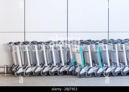 I carrelli per i bagagli dei passeggeri all'ingresso dell'edificio del terminal dell'aeroporto Foto Stock