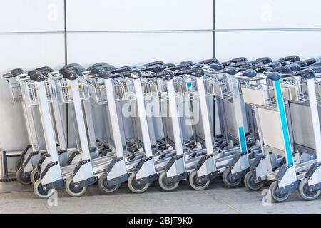 I carrelli per i bagagli dei passeggeri all'ingresso dell'edificio del terminal dell'aeroporto Foto Stock