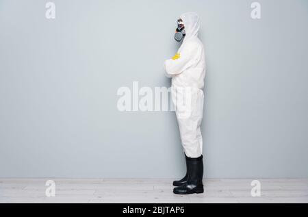 Foto del profilo del corpo di un professionista Guy disinfettante guardare luoghi pubblici disinfezione braccia incrociate indossare zaccat tuta protettiva occhiali maschera guanti Foto Stock