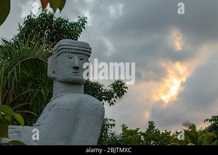 Dettaglio della statua di Chac Mool sul viso contro il cielo nuvoloso. Mayanand Aztec Chacmool simboleggiò guerrieri uccisi che portavano offerte agli dei. Foto Stock