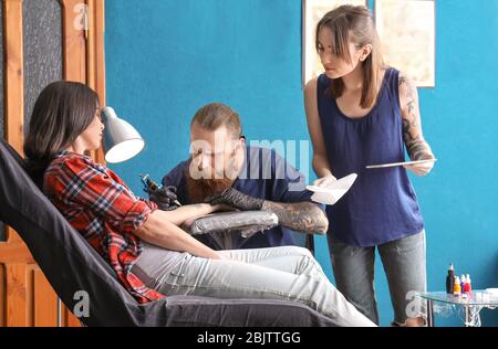 Tirocinante professionista di insegnamento dell'artista in salone. Concetto di apprendistato Foto Stock