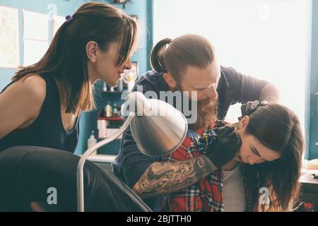 Tirocinante professionista di insegnamento dell'artista in salone. Concetto di apprendistato Foto Stock