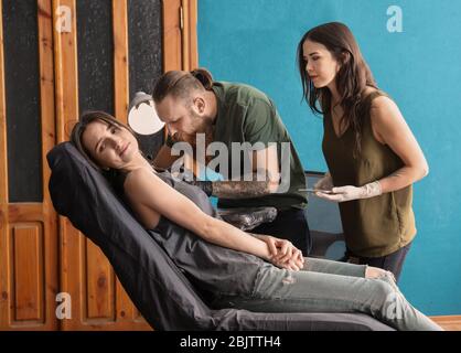 Tirocinante professionista di insegnamento dell'artista in salone. Concetto di apprendistato Foto Stock