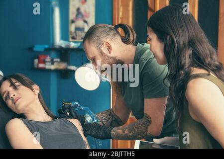 Tirocinante professionista di insegnamento dell'artista in salone. Concetto di apprendistato Foto Stock