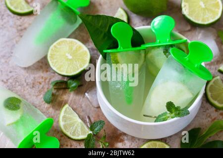 Papicole fatte in casa con succo di lime e menta, mojito frutta ghiaccio su una pietra leggera o ardesia sfondo. Foto Stock