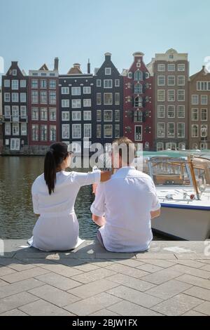 Coppia in un viaggio in città ad Amsterdam, uomini e donne che si rilassano nei canali di Amsterdam nella primavera del 2020 aprile in Europa Paesi Bassi Foto Stock