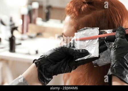 Parrucchiere professionale a lavorare con il cliente in salone Foto Stock