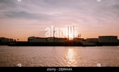 Porto di Rotterdam Paesi Bassi 2020 aprile, serbatoi di stoccaggio di gas e petrolio con petroliera nel porto durante il tramonto Foto Stock