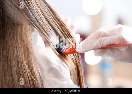 Parrucchiere professionale che muore i capelli del cliente in salone di bellezza, closeup Foto Stock