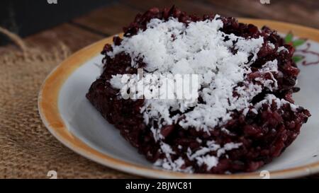 Riso adesivo nero o Ketan Hitam (nome indonesiano) con cocco grattugiato, molto delizioso e dolce Foto Stock