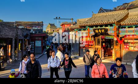 Pechino / Cina - 9 ottobre 2018: Vecchia via Gulou hutong, con molti negozi e ristoranti tradizionali e Campanile sullo sfondo a Pechino, C. Foto Stock