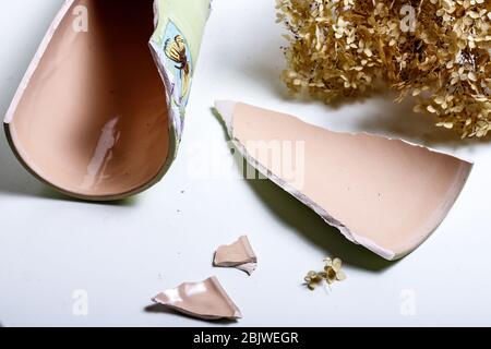 Un vecchio rotto caraffa colorata di argilla giace sul suolo asciutto sul terreno in Sicilia Foto Stock