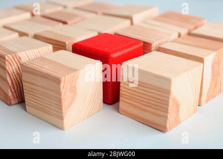 Un cubo rosso tra quelli in legno a tavola. Concetto di differenza e unicità Foto Stock