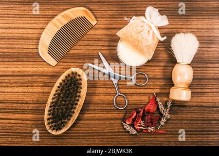 Set di bellezza con diverse fragranze su un tavolo di legno. Pettine, forbici per capelli e gel da bagno tra gli altri strumenti cosmetici. Foto Stock