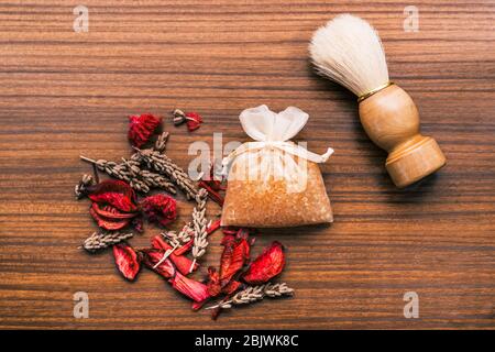 Set di bellezza con diverse fragranze su un tavolo di legno. Gel da bagno, petali di fiori ed erbe aromatiche tra gli altri prodotti cosmetici. Foto Stock
