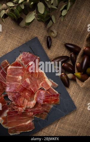 Prosciutto Ghianda concetto. Prodotto di carne di maiale alimentato con Ghiande di quercia, noto anche in Spagna come nero prosciutto zampe Foto Stock