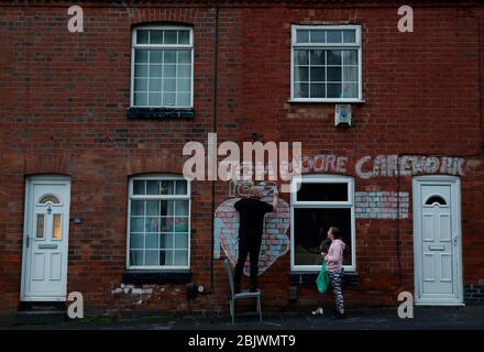 Anstey, Leicestershire, Regno Unito. 30 aprile 2020. Kevin e Ayla Ward hanno messo i tocchi finali al loro tributo ai lavoratori NHS e al capitano Tom Moore prima dell'evento di Clap for Carers, un pandemo di coronavirus. Credit Darren Staples/Alamy Live News. Foto Stock