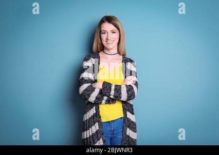 Giovane donna in cardigan a righe su sfondo colorato Foto Stock