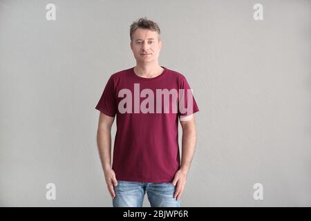 Uomo in t-shirt a colori su sfondo chiaro. Mockup per il design Foto Stock