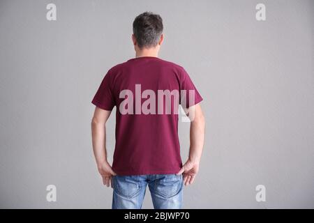 Uomo in t-shirt a colori su sfondo chiaro. Mockup per il design Foto Stock