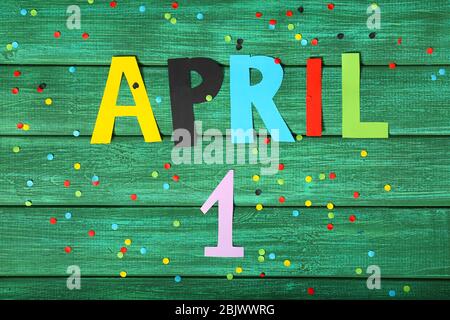 Composizione con confetti e frase '1 aprile' su sfondo colorato. Festa dello sciocco Foto Stock