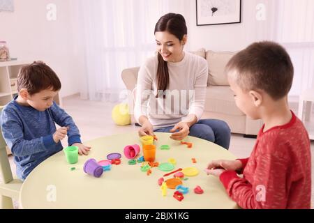 Nanny e ragazzi che scolpiscono dalla plastilina a casa Foto Stock