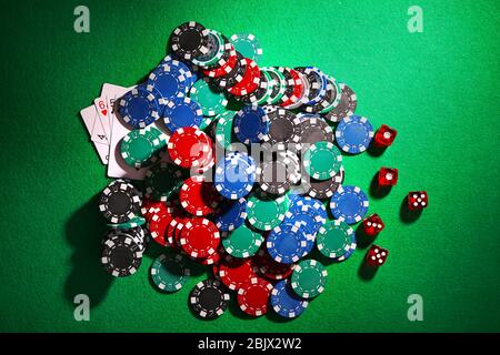 Chip per poker e dadi sul tavolo verde nel casinò Foto Stock