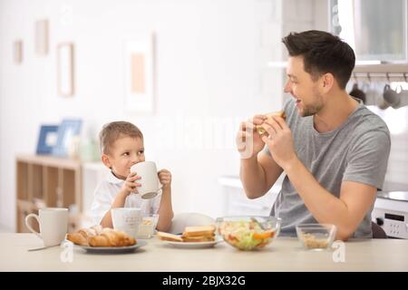 Padre con figlio che ha colazione in cucina Foto Stock