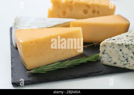 Piatto con diversi formaggi su sfondo bianco. Prodotti lattiero-caseari freschi Foto Stock