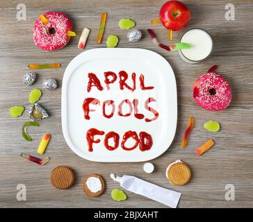 Composizione con frase 'Aprile sciola il cibo' e tratta su sfondo legno Foto Stock