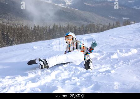 Snowboarder femmina divertirsi sulla pista da sci nella località innevata. Vacanze invernali Foto Stock