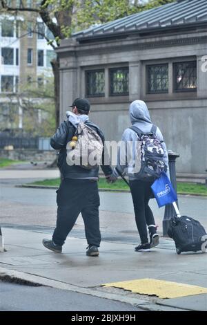 Boston, Massachusetts, Stati Uniti. 30 Aprile 2020. COVID 19 CORONA VIRUS PANDEMIC - una coppia vagare le strade di Boston vicino a Boston Common tenere le mani e continuare a camminare per le strade vuote. Credit: Kenneth Martin/ZUMA Wire/Alamy Live News Foto Stock