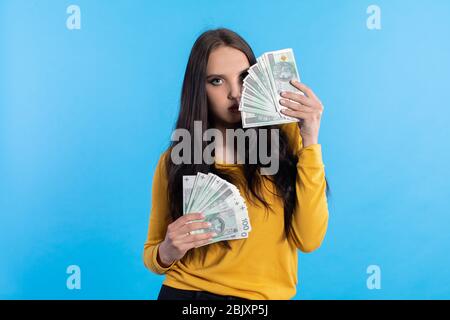 L'adolescente tiene in mano una grande somma di denaro ed è pronto a darle. Foto Stock