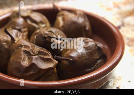 Immagine di pere arrosto cotto in casa in una pentola di argilla con illuminazione finestra e pronto a mangiare Foto Stock
