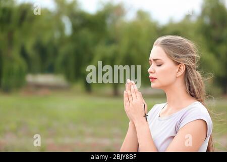 Giovane donna in preghiera a Dio all'aperto Foto Stock