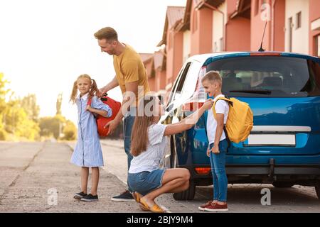 I genitori di dire addio ai loro figli vicino a scuola Foto Stock