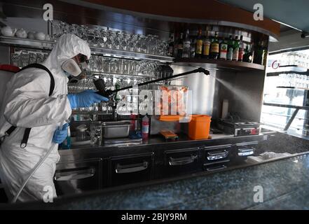 Roma, Italia. 30 Aprile 2020. Un lavoratore disinfetta un bar chiuso a Roma, 30 aprile 2020. L'Italia ha registrato giovedì il maggior numero di recuperi giornalieri di coronavirus dall'inizio dell'emergenza a fine febbraio, ha dichiarato il Dipartimento della protezione civile del Paese. Il numero di vittime di giovedì è stato di 285, portando il totale a 27,967 nel paese. Le nuove infezioni del giorno sono state 1,872, portando il numero totale di casi, che combinavano infezioni, decessi e recuperi, in Italia a 205,463. Credit: Alberto Lingria/Xinhua/Alamy Live News Foto Stock