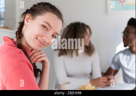 Donna sorridente mentre si aggende con friendsÂ Foto Stock