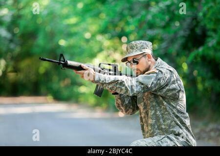 Soldato in camuffamento prendendo mirano all'aperto Foto Stock