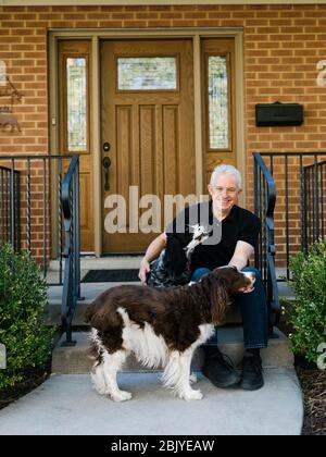 English springer spaniels e proprietario di fronte alla casa Foto Stock