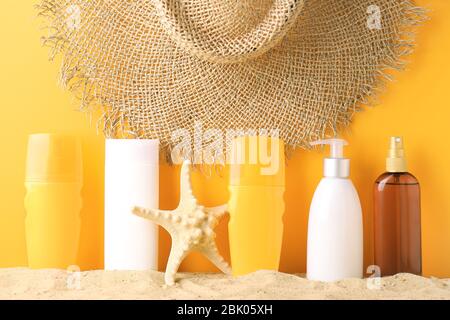 Sun diverse creme di protezione sulla sabbia contro il colore di sfondo Foto Stock