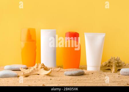 Sun diverse creme di protezione sulla sabbia contro il colore di sfondo Foto Stock