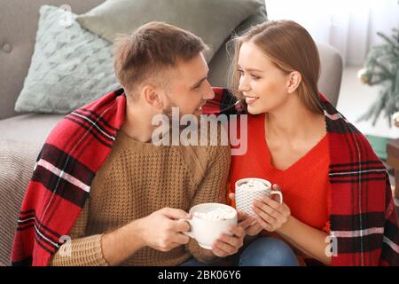 Coppia giovane di bere cioccolata calda a casa Foto Stock