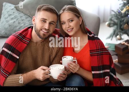 Coppia giovane di bere cioccolata calda a casa Foto Stock