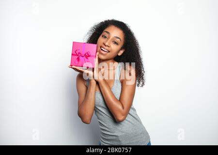 Ritratto di bella donna afro-americana con confezione regalo su sfondo bianco Foto Stock