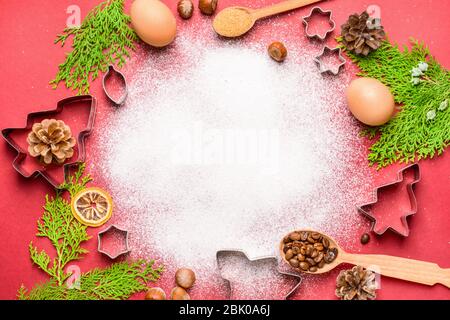 Composizione di natale con cookie cutter e farina sul colore di sfondo Foto Stock