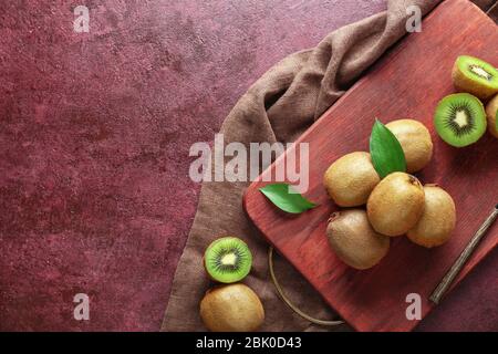 Tagliere con gustosi kiwi sul tavolo Foto Stock