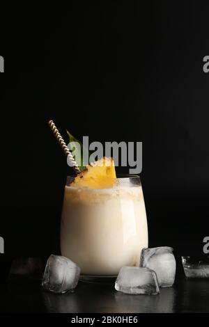 Bicchiere di gustosa Pina Colada cocktail su sfondo scuro Foto Stock