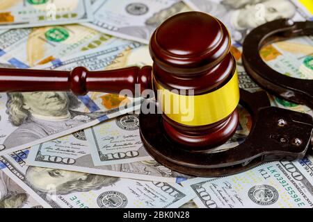 Il gavel del giudice del legno con i manette sulla vista da cento fatture del dollaro degli Stati Uniti in corte Foto Stock