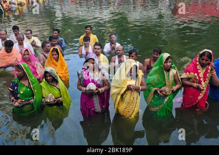 Durante il festival Chhath Puja, adoratori, per lo più migranti dalla provincia di Bihar, si trovano a Banganga Tank, Mumbai, India, per pregare verso il sole che tramonta Foto Stock